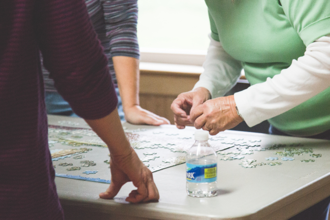 Three people working on a jigsaw puzzle